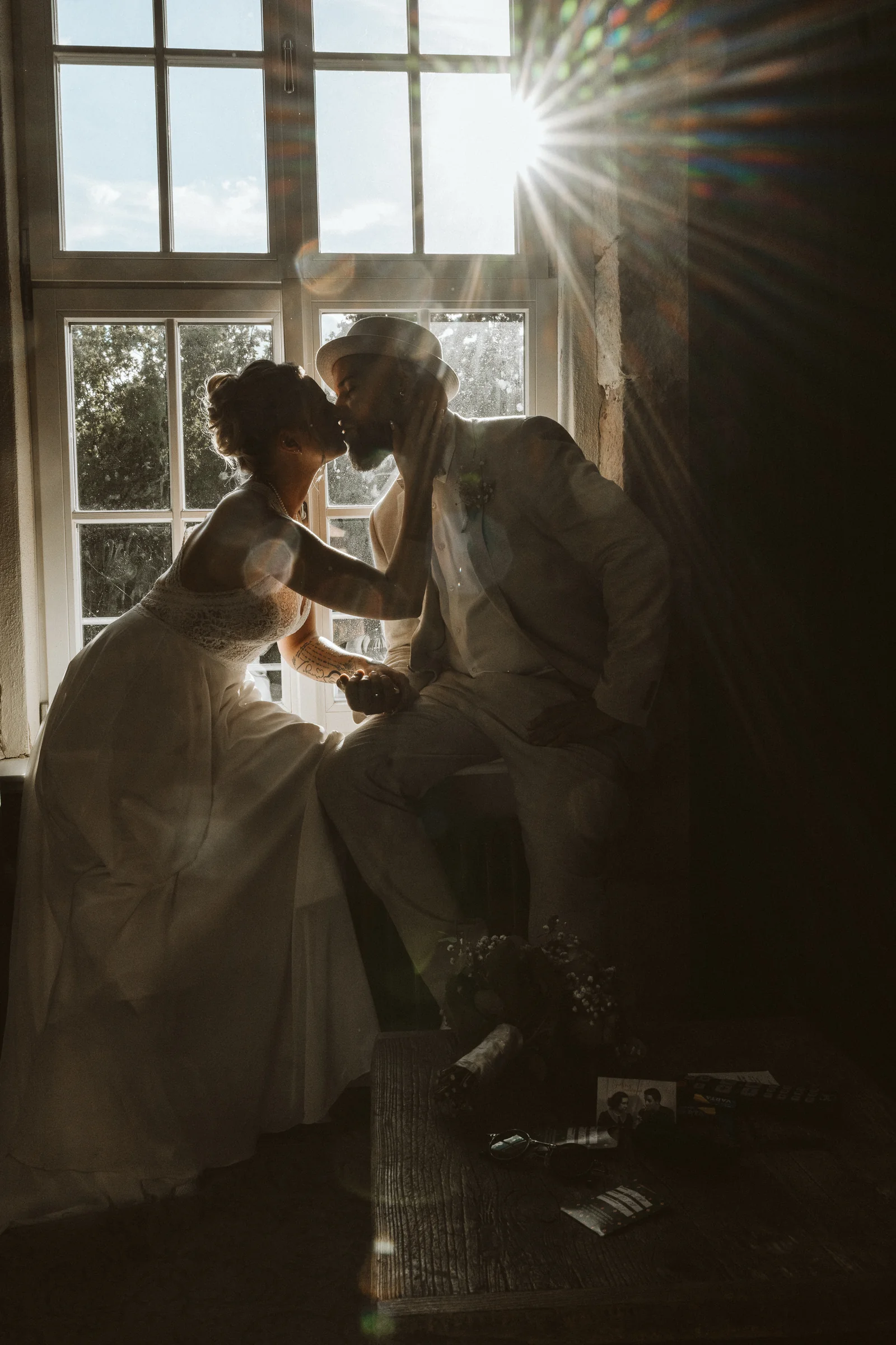 Hochzeitspaar bei Sonnenuntergang am Fenster
