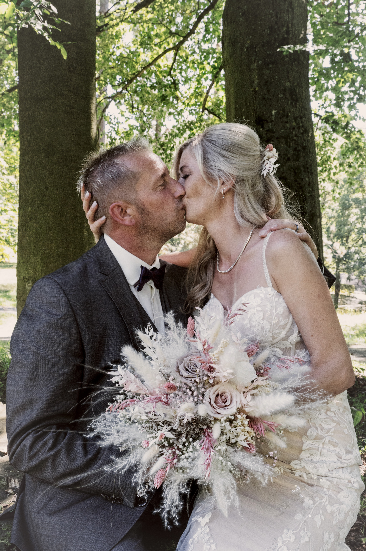 Brautpaar küsst sich unter Bäumen – Hochzeitsfotografie by Jo