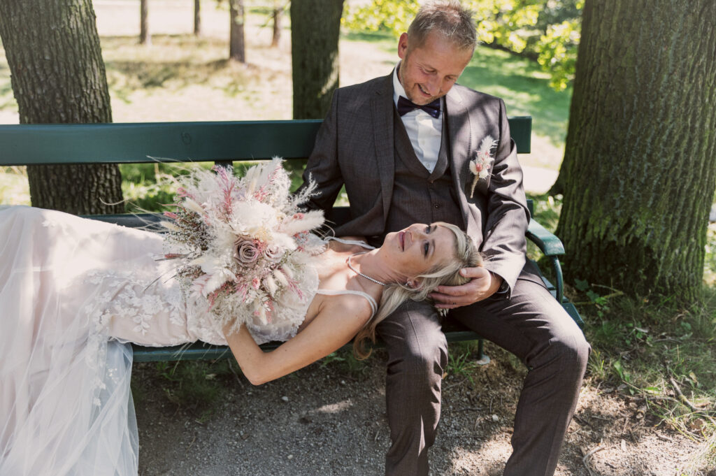 Braut liegt mit Strauß auf der Bank – Hochzeitsfotografie by Jo