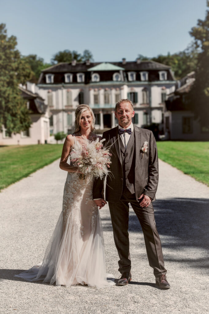 Brautpaar vor dem Schloss – Hochzeitsfotografie by Jo