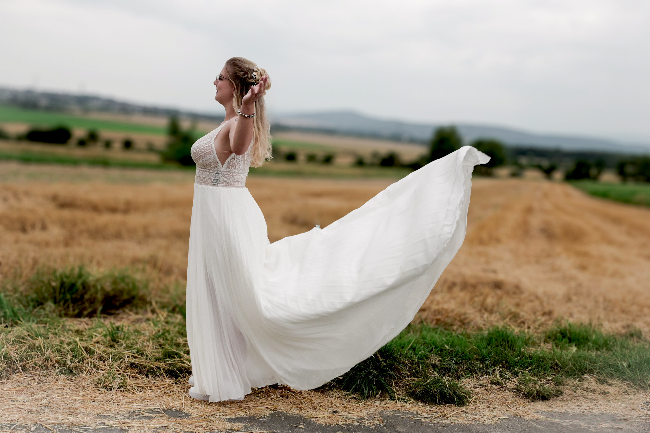 Braut mit wehendem Kleid im Feld – Hochzeitsfotografie by Jo